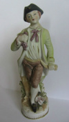 Фигурка мальчика. Фарфор, бисквит. (Небольшие сколы на лепестках цветка) Клейм нет. Высота 18 см.